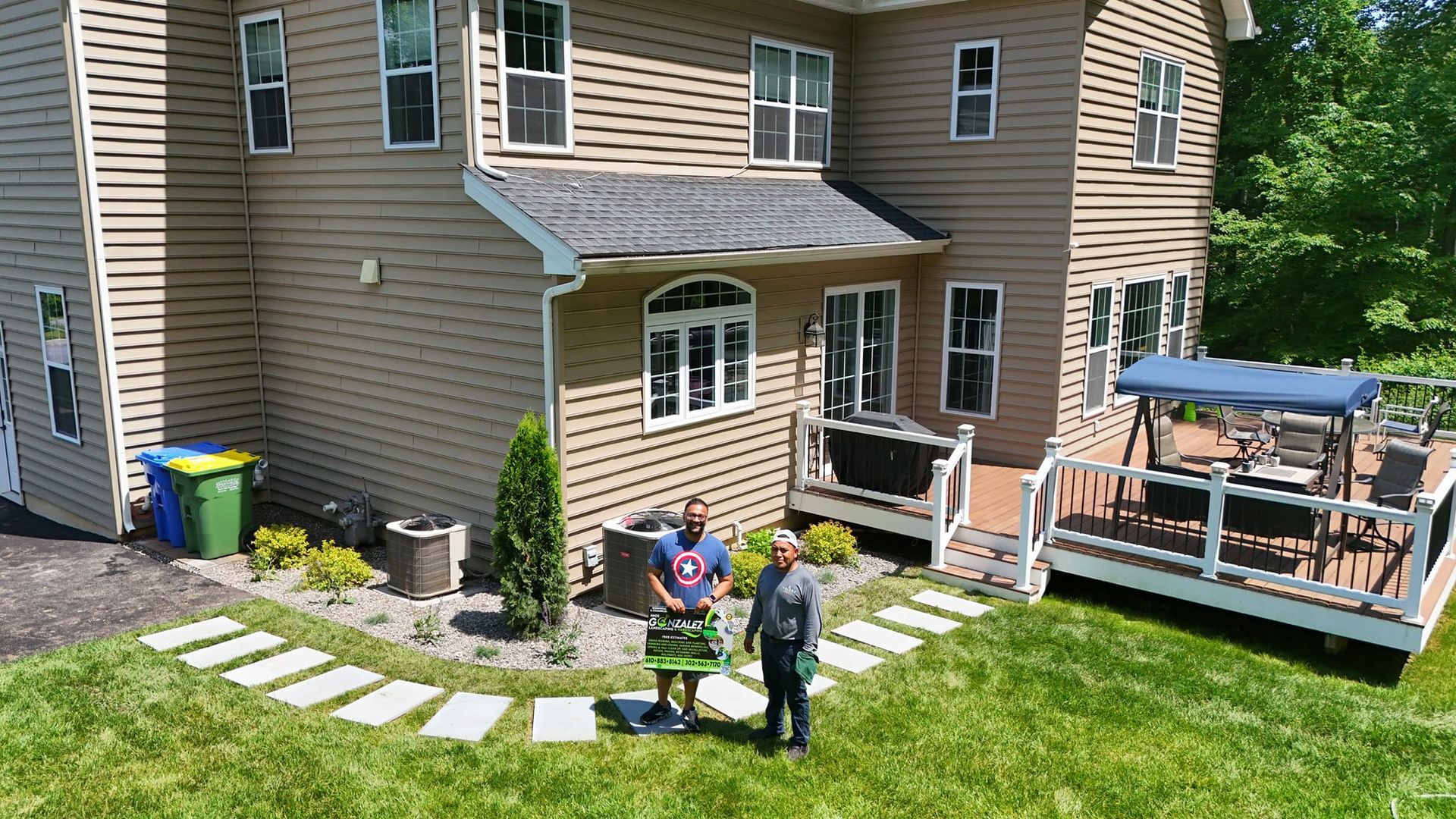 Two men are standing in front of a large house.