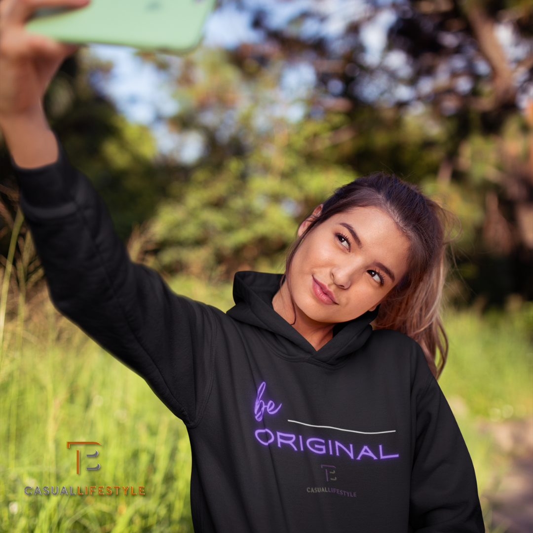 A woman wearing a black hoodie that says be original takes a selfie