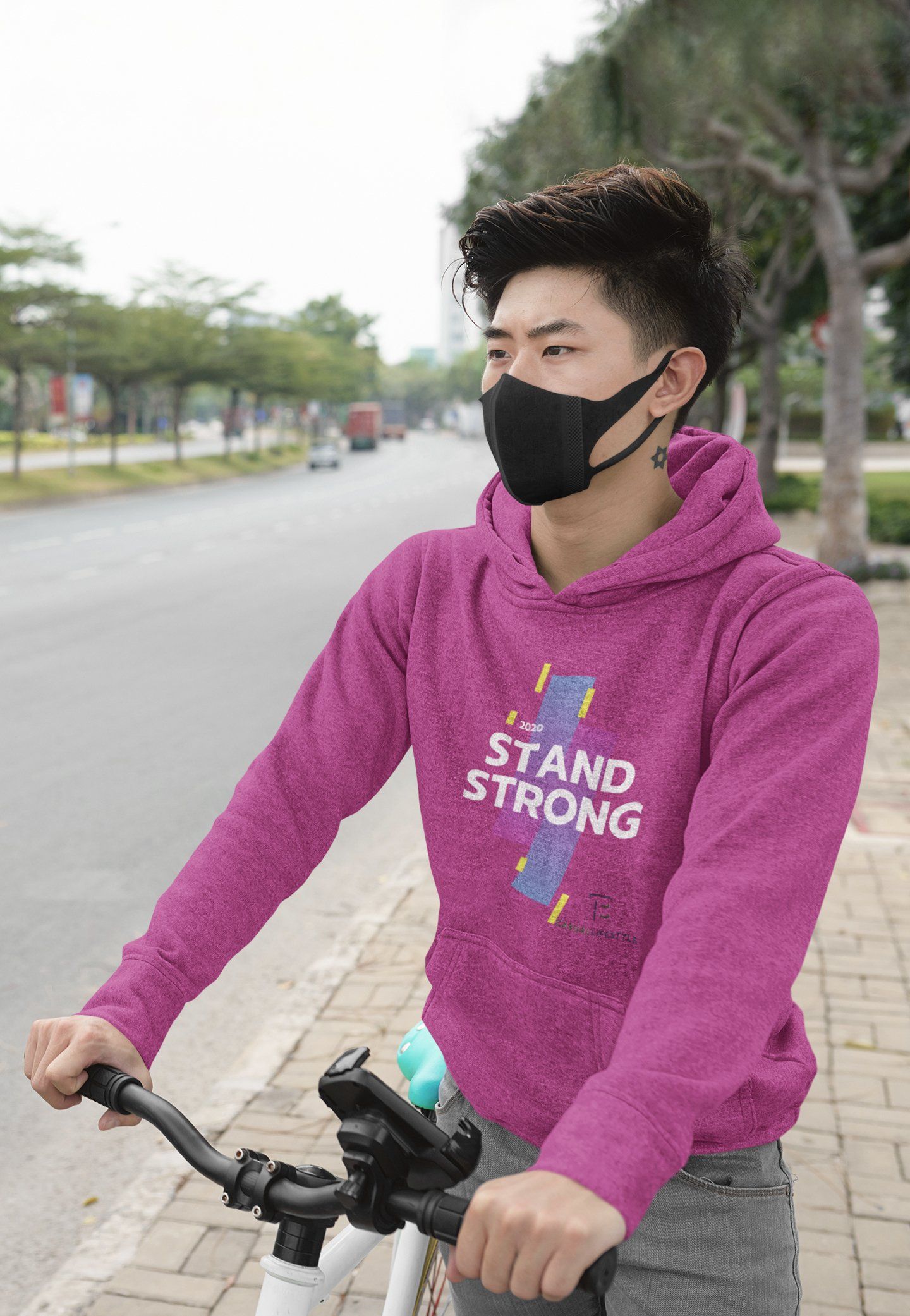 A man wearing a purple hoodie and a black mask is riding a bike.