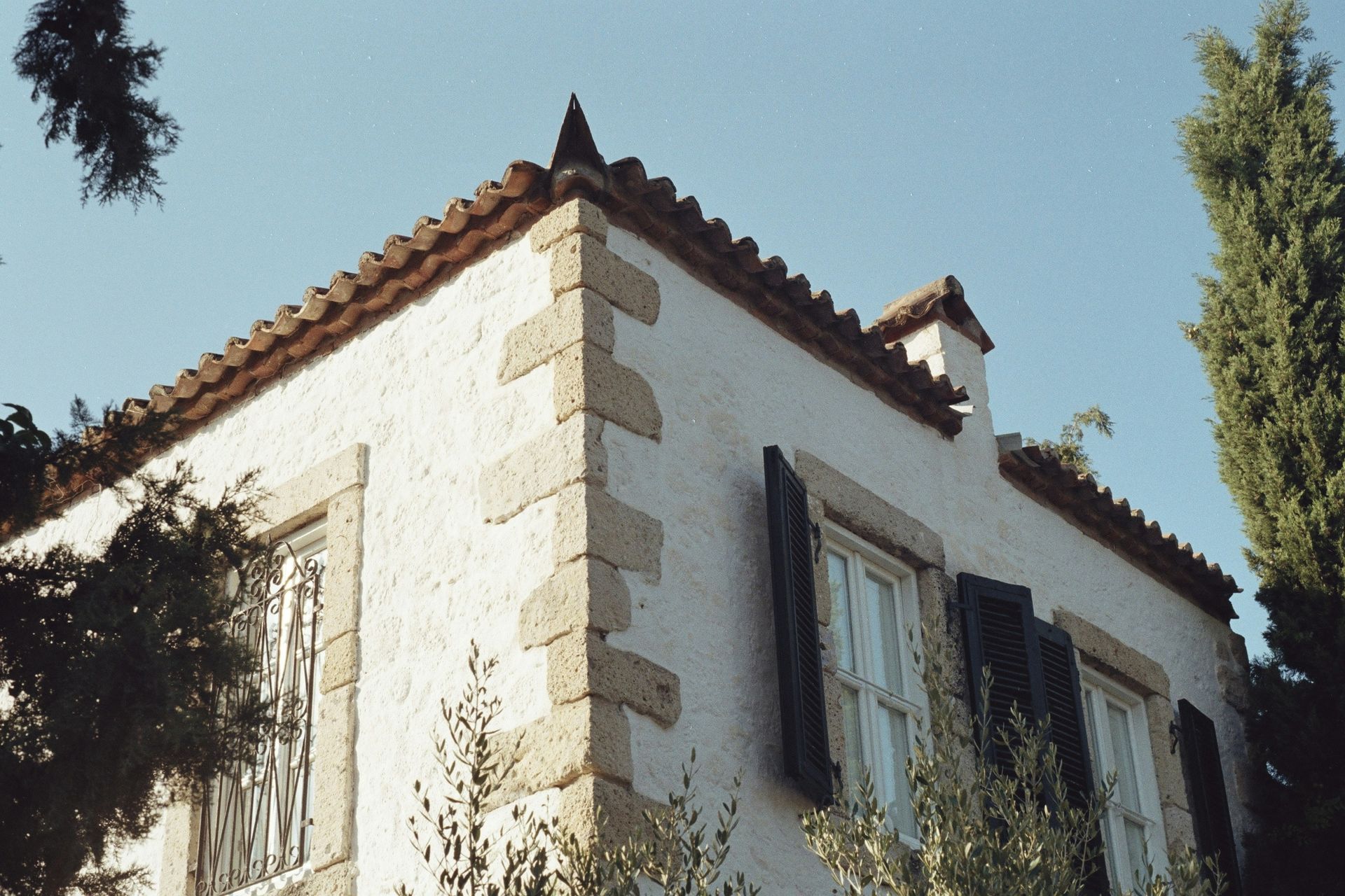 A white building with a tiled roof and black shutters