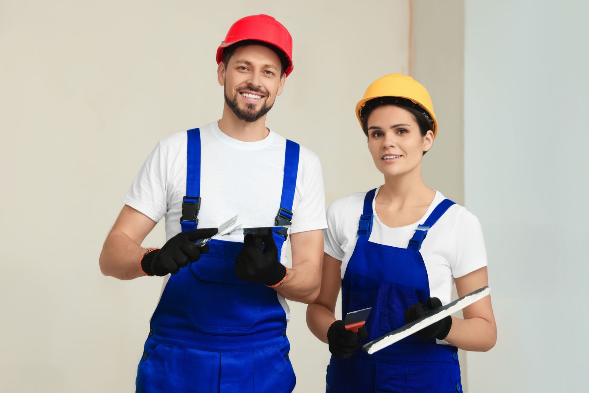 A man and a woman are standing next to each other holding tools.