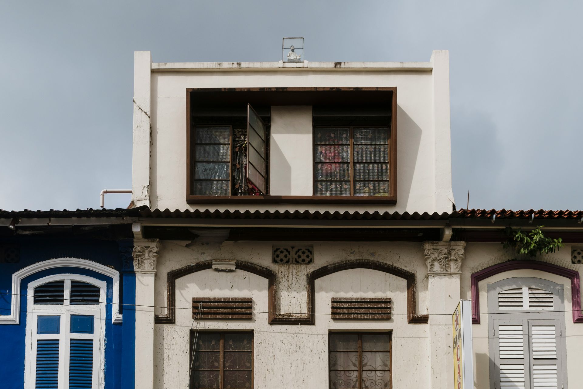 A white building with a blue building in the background