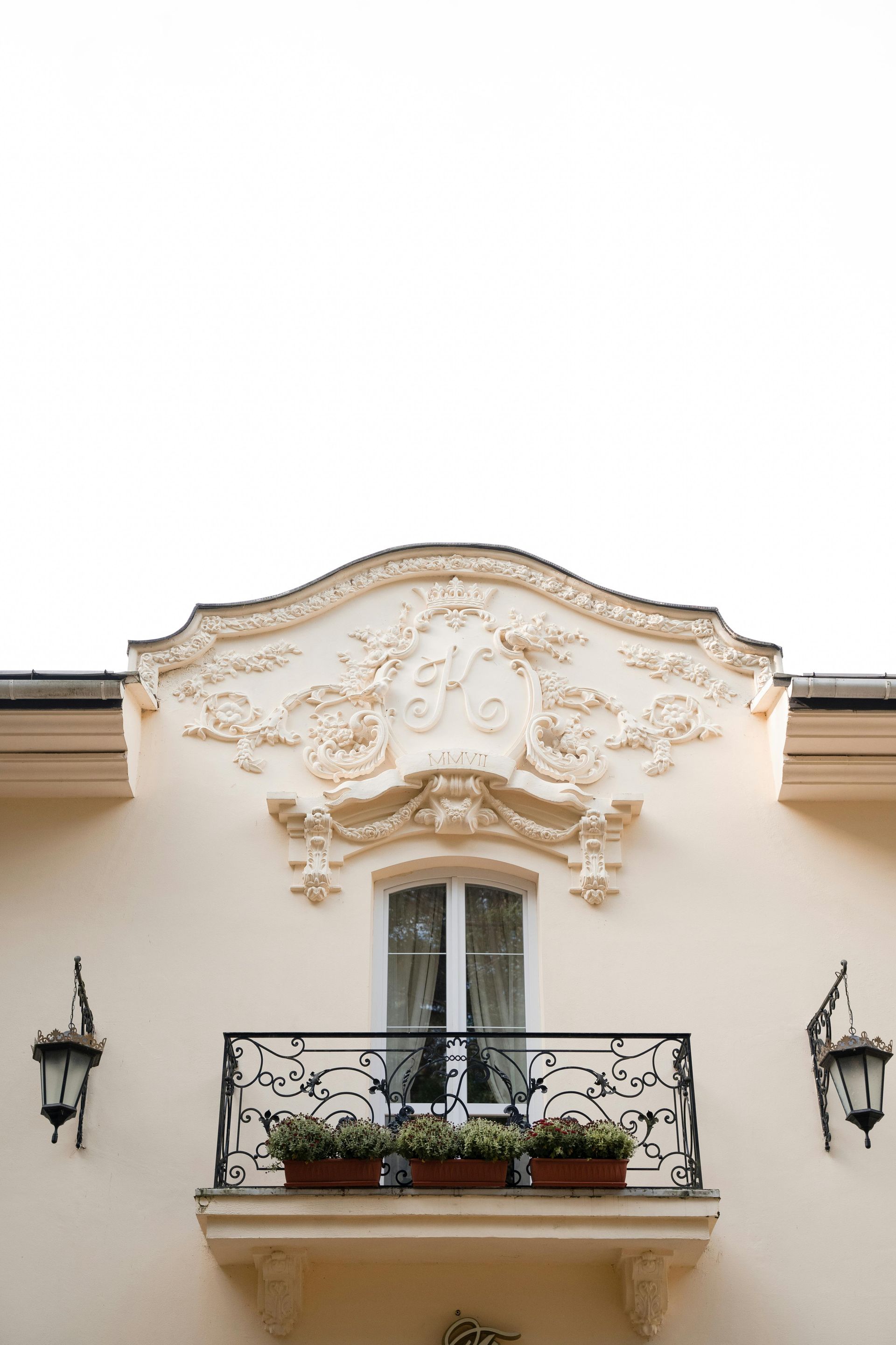 A white building with two wooden doors and a window.
