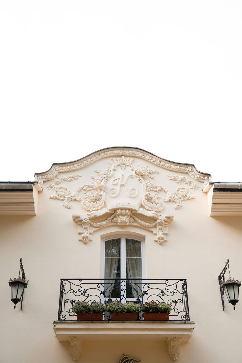 A white building with a balcony and a window.