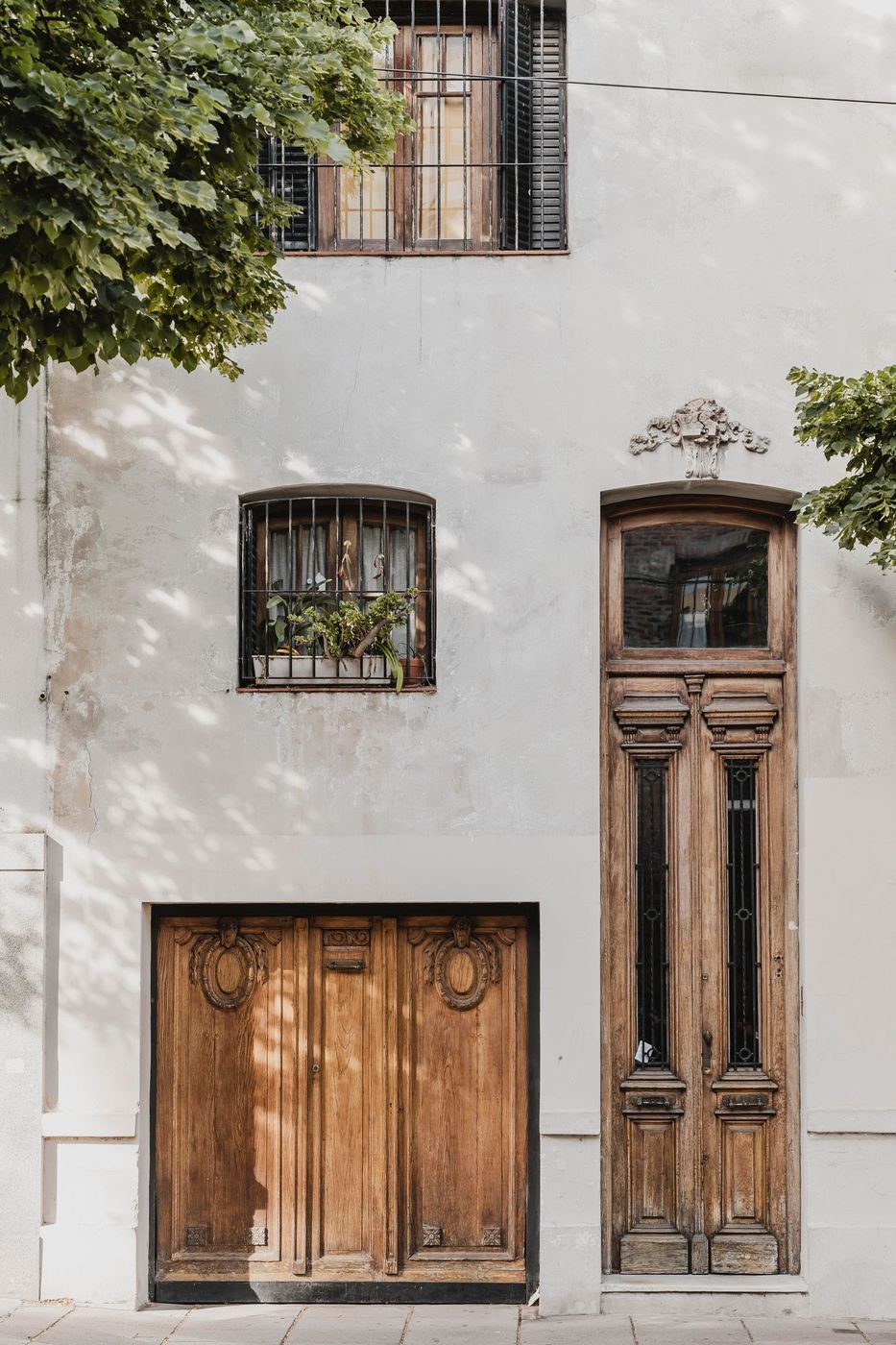 A white building with two wooden doors and a window.