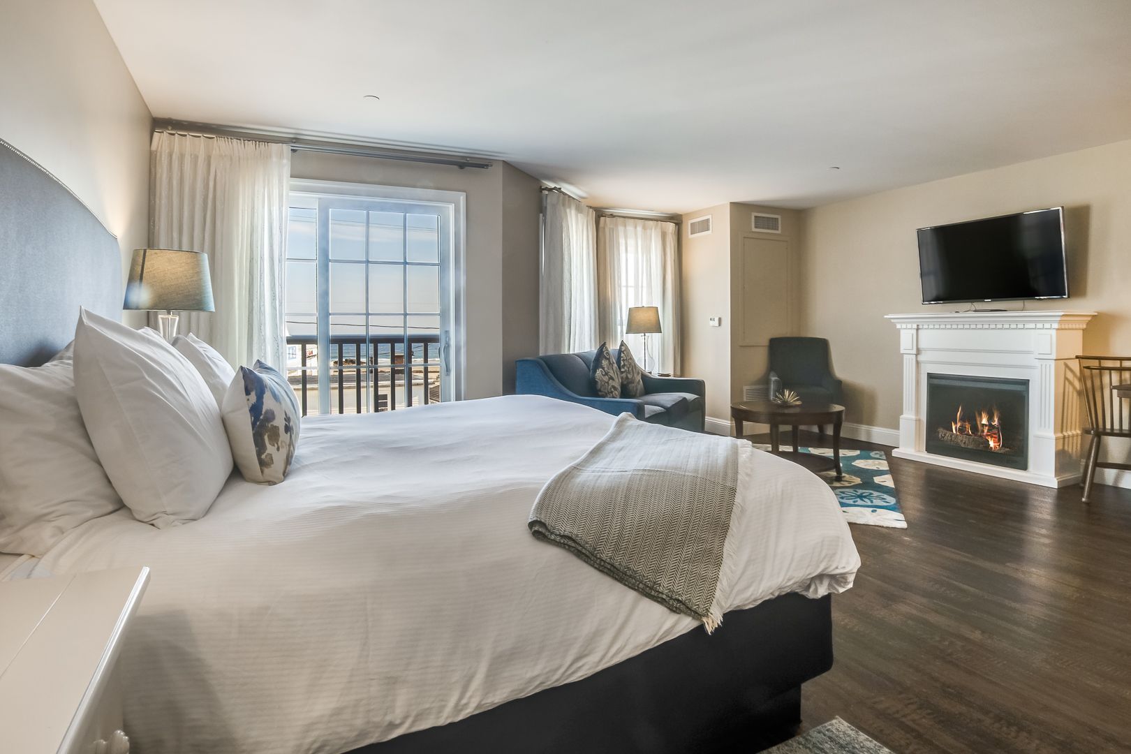 Empty room with built-in white cabinets, open shelves, two small windows, and dark wood flooring.