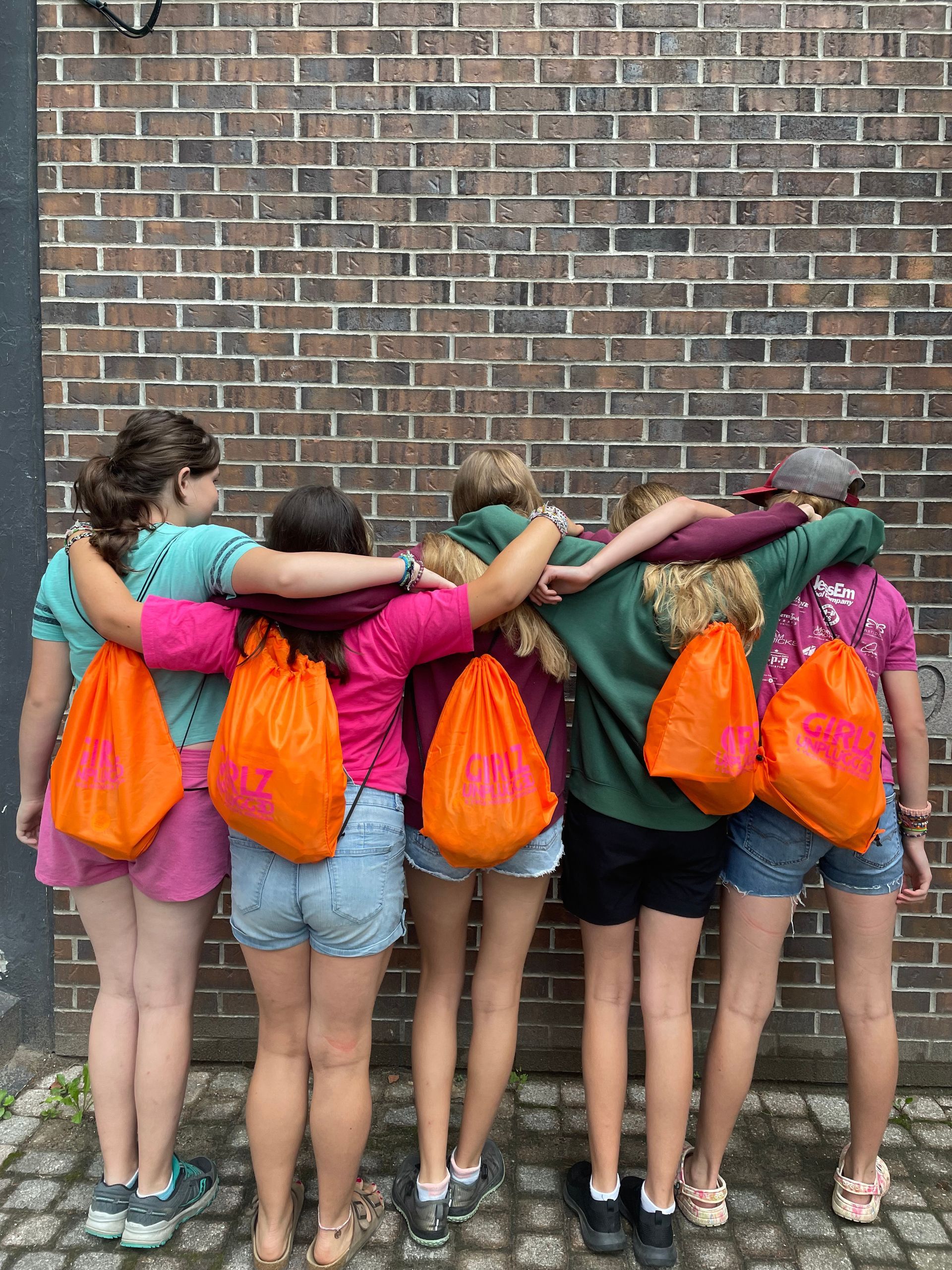 girlz unplugged campers wearing logo backpacks