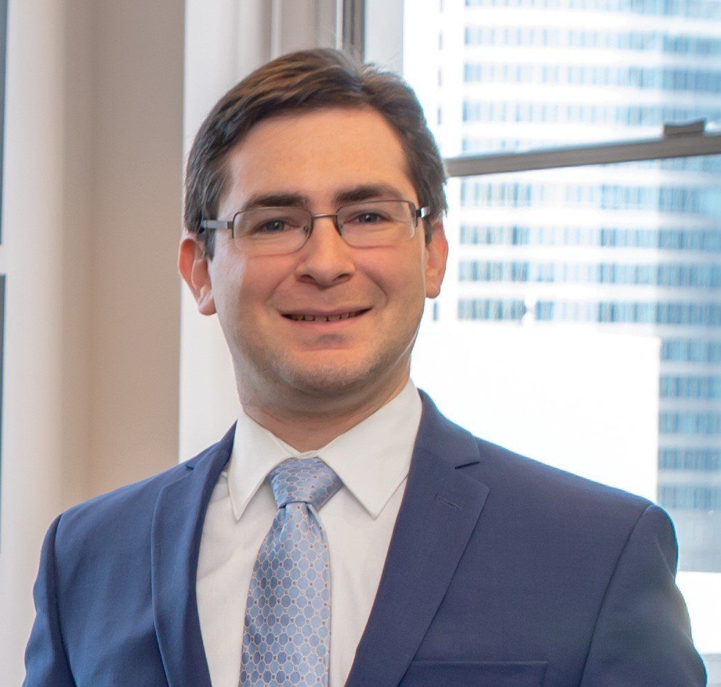 A man in a suit and tie is smiling for the camera