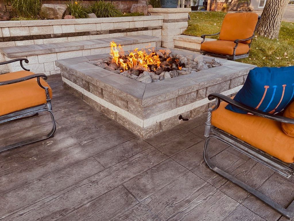 A fire pit in the middle of a stone patio