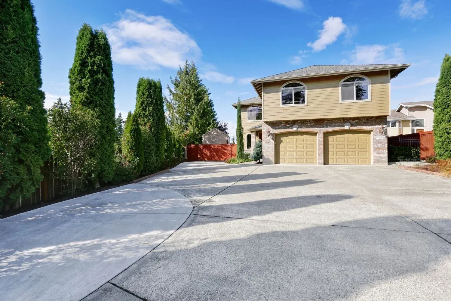 A large house with a concrete driveway leading to it.