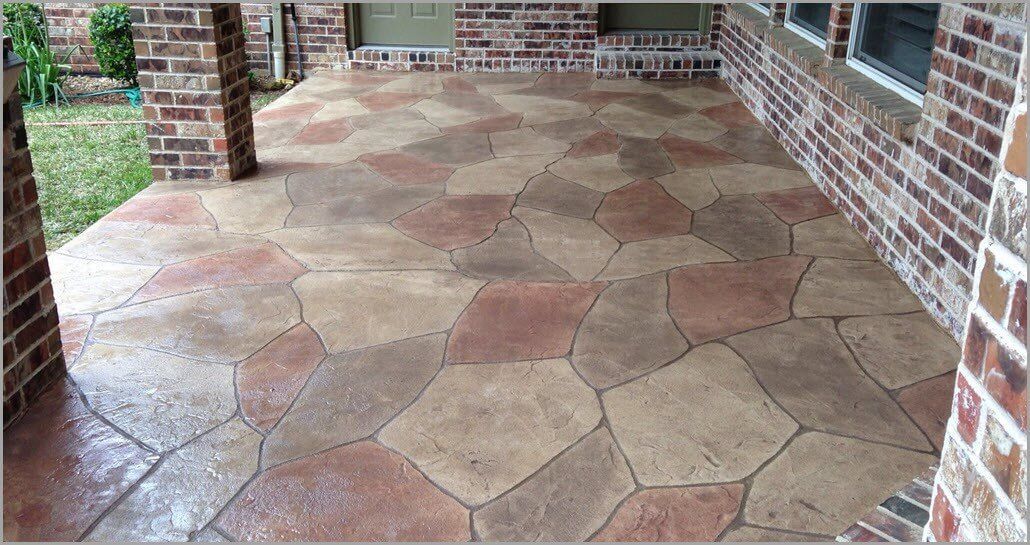 A patio with a brick wall and a concrete floor