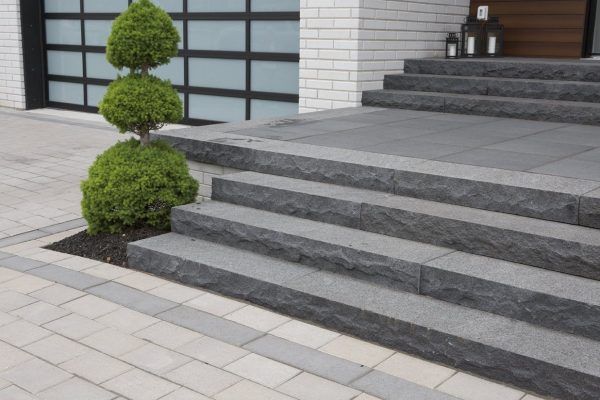 A set of stairs leading up to a house with a tree in the middle.