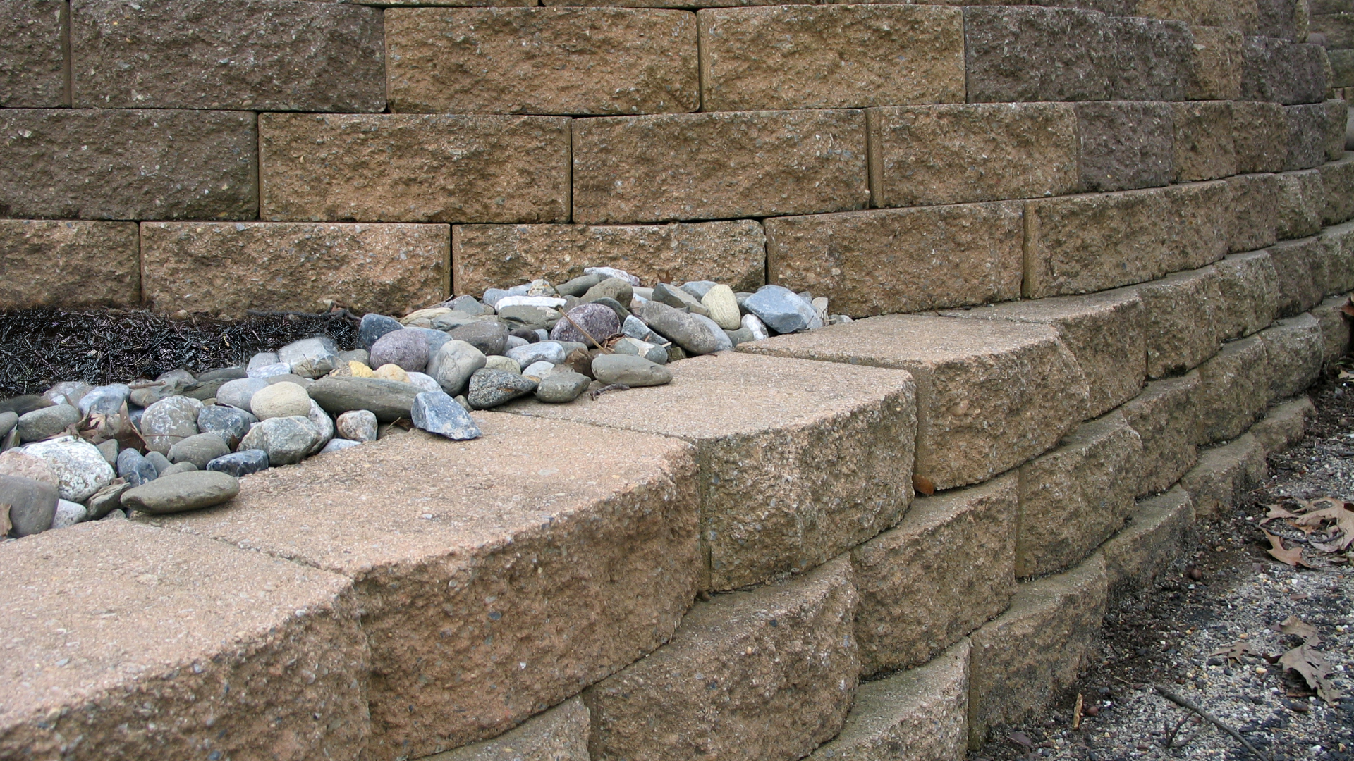 A stone wall with rocks on the side of it