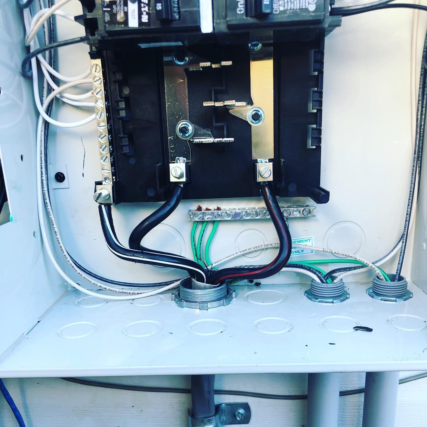 Open electrical panel with wires and circuit breakers.