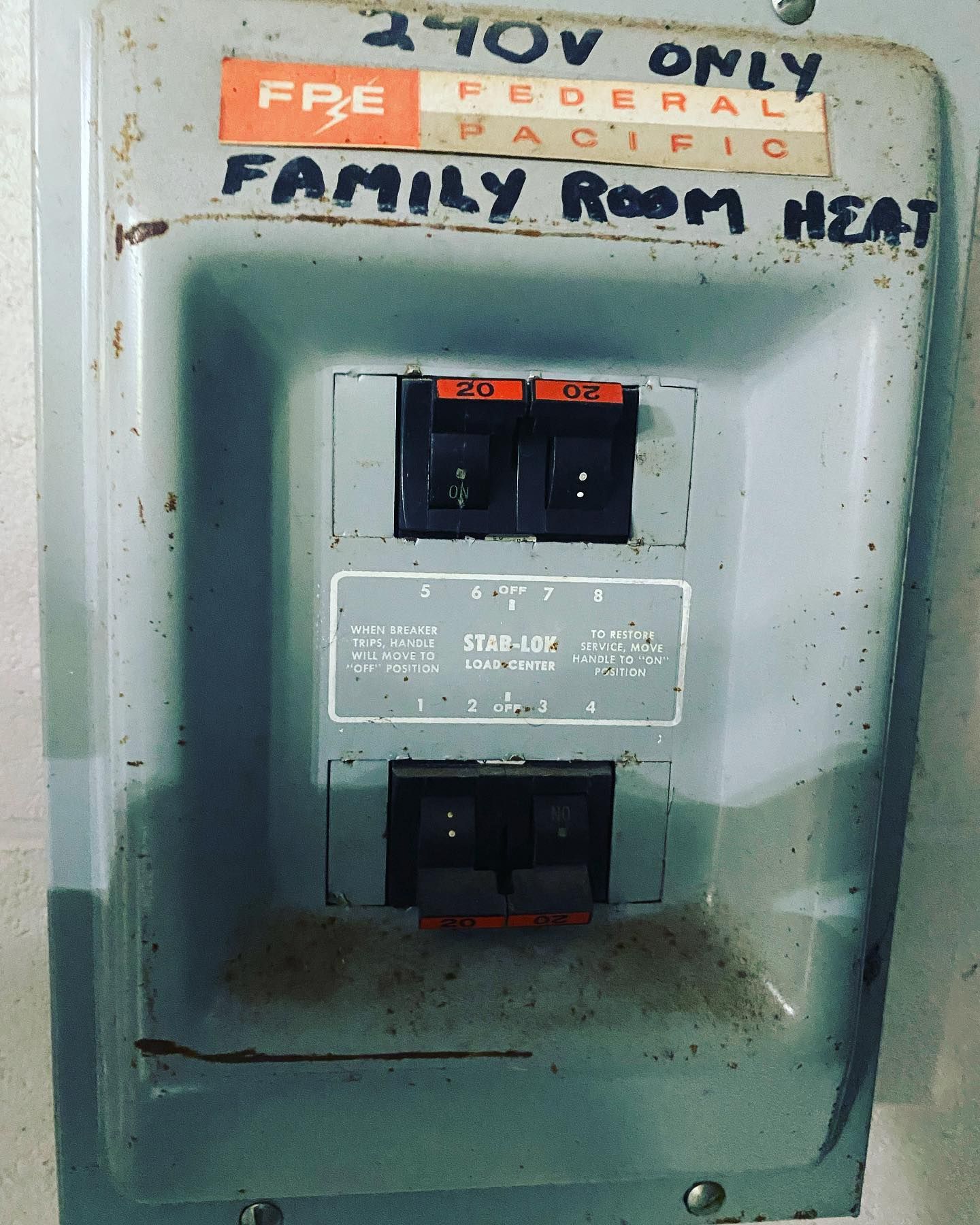 Metal electrical panel with two circuit breakers labeled 