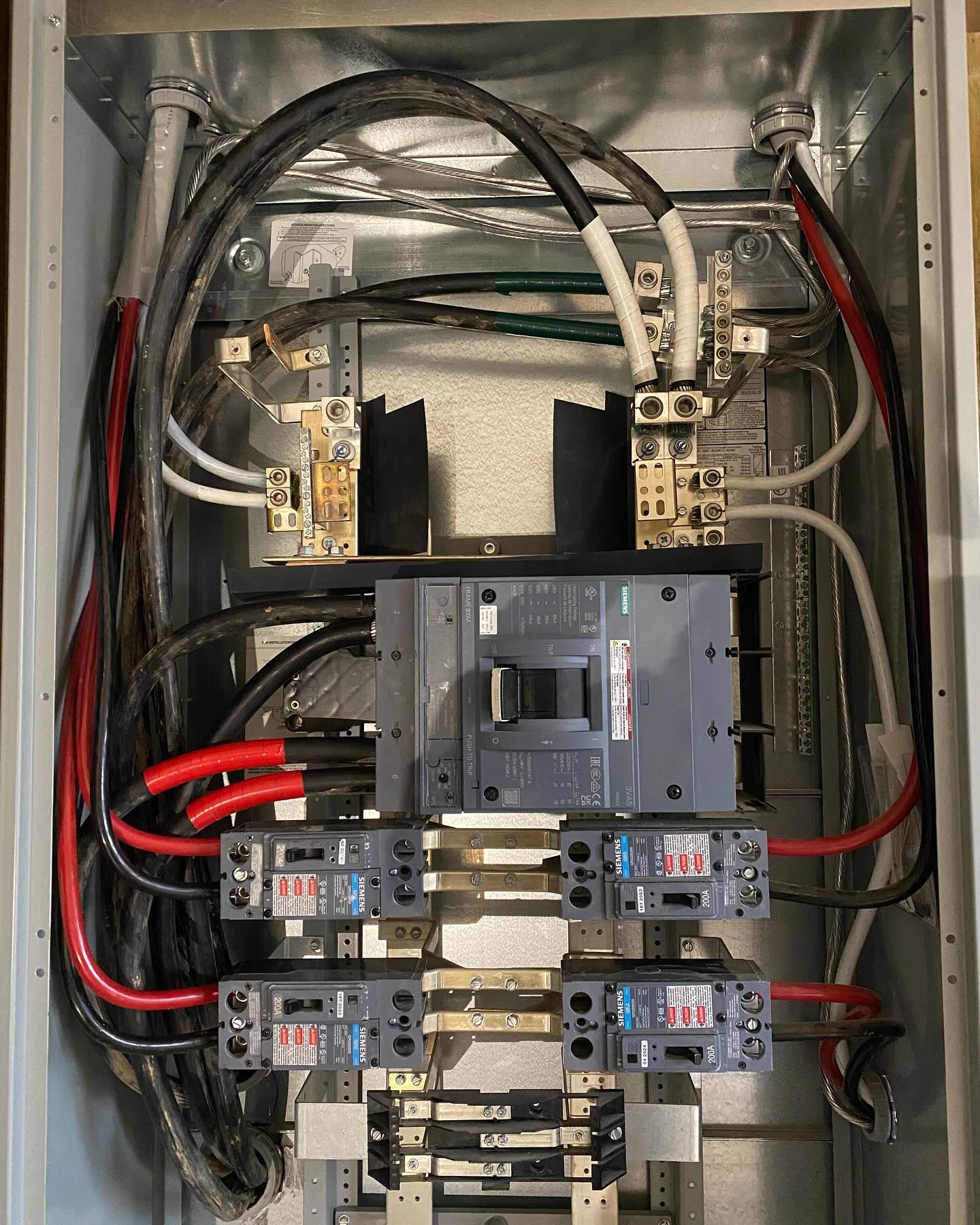 Electrical panel with wires and circuit breakers.