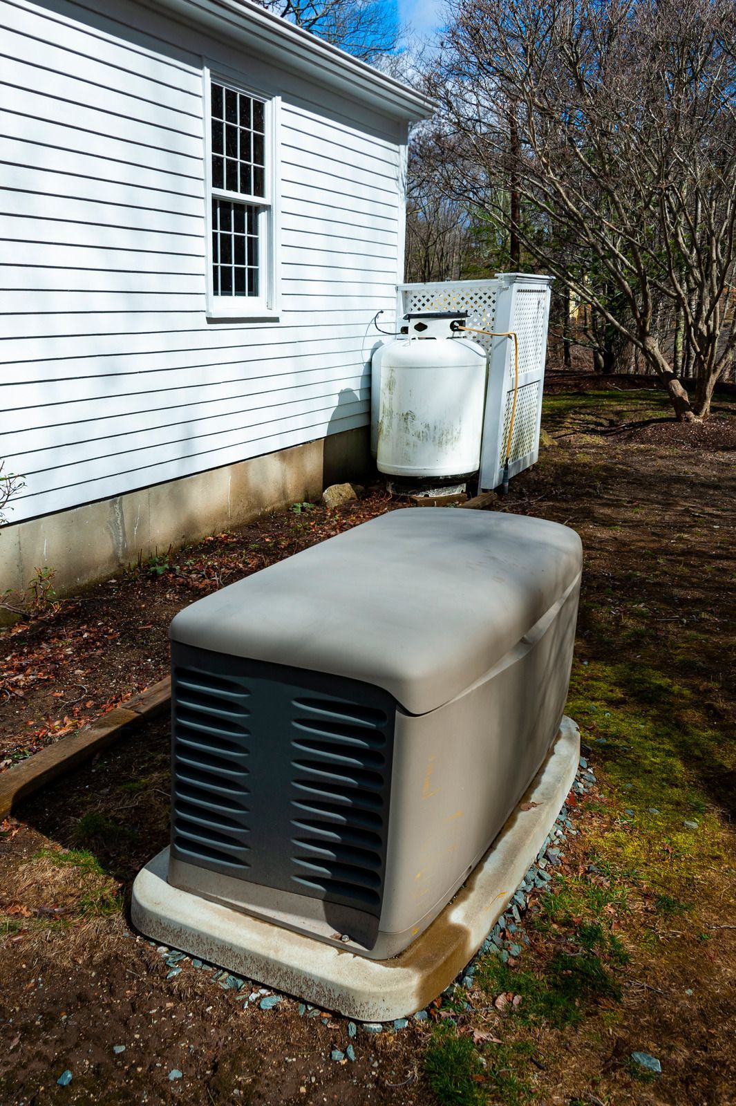 Woman in green uniform smiles, holding papers, surrounded by plants in a bright hallway.