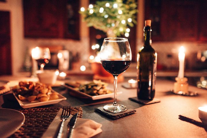 Romantica tavola apparecchiata con vino, cibo e candele.