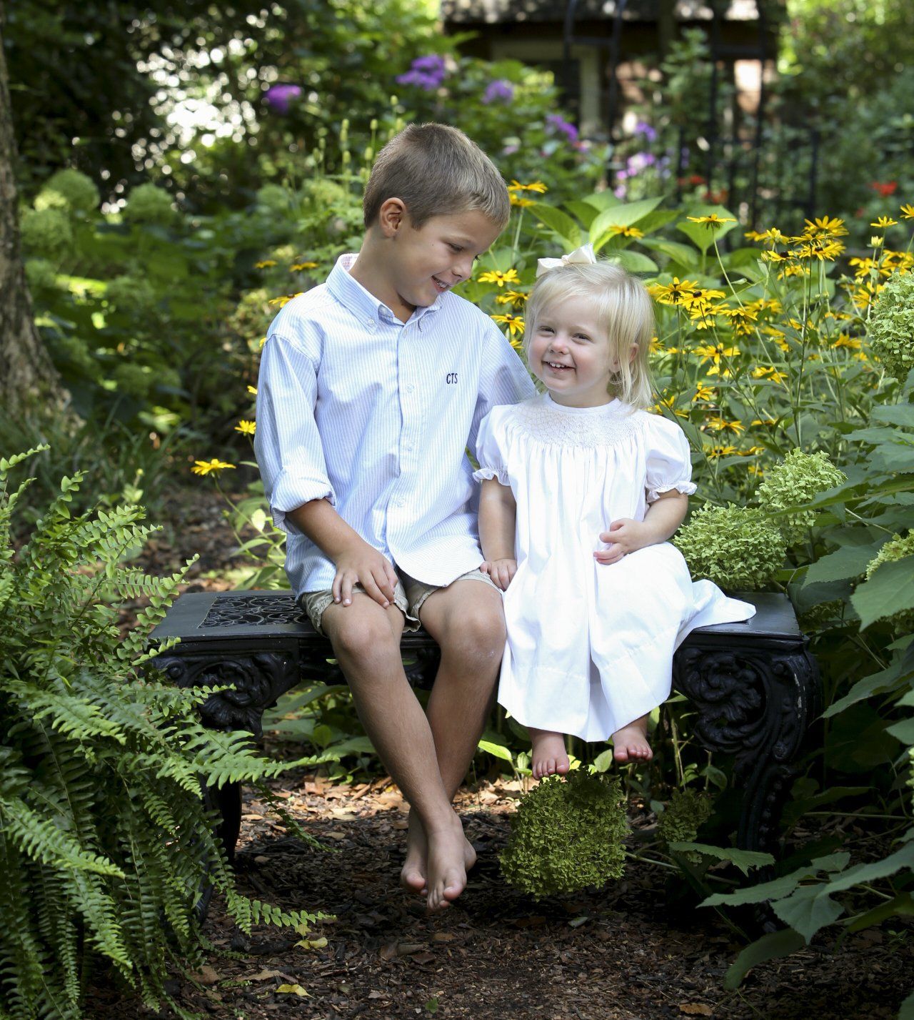 Brother and sister playing outside by water