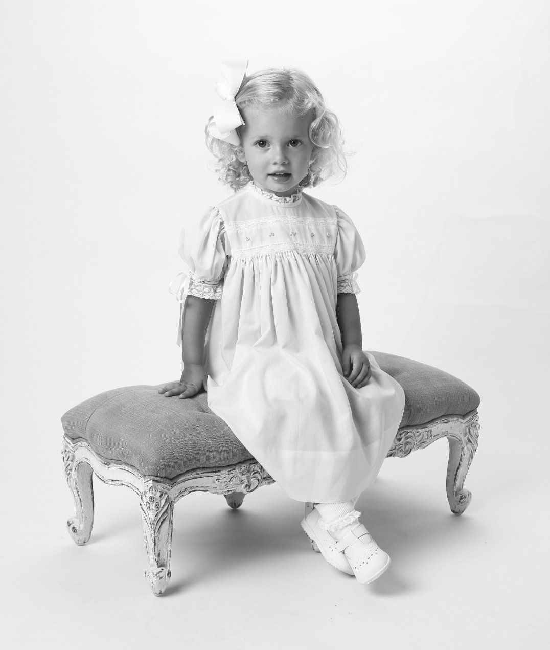 Vintage baby portrait of girl sitting on bench