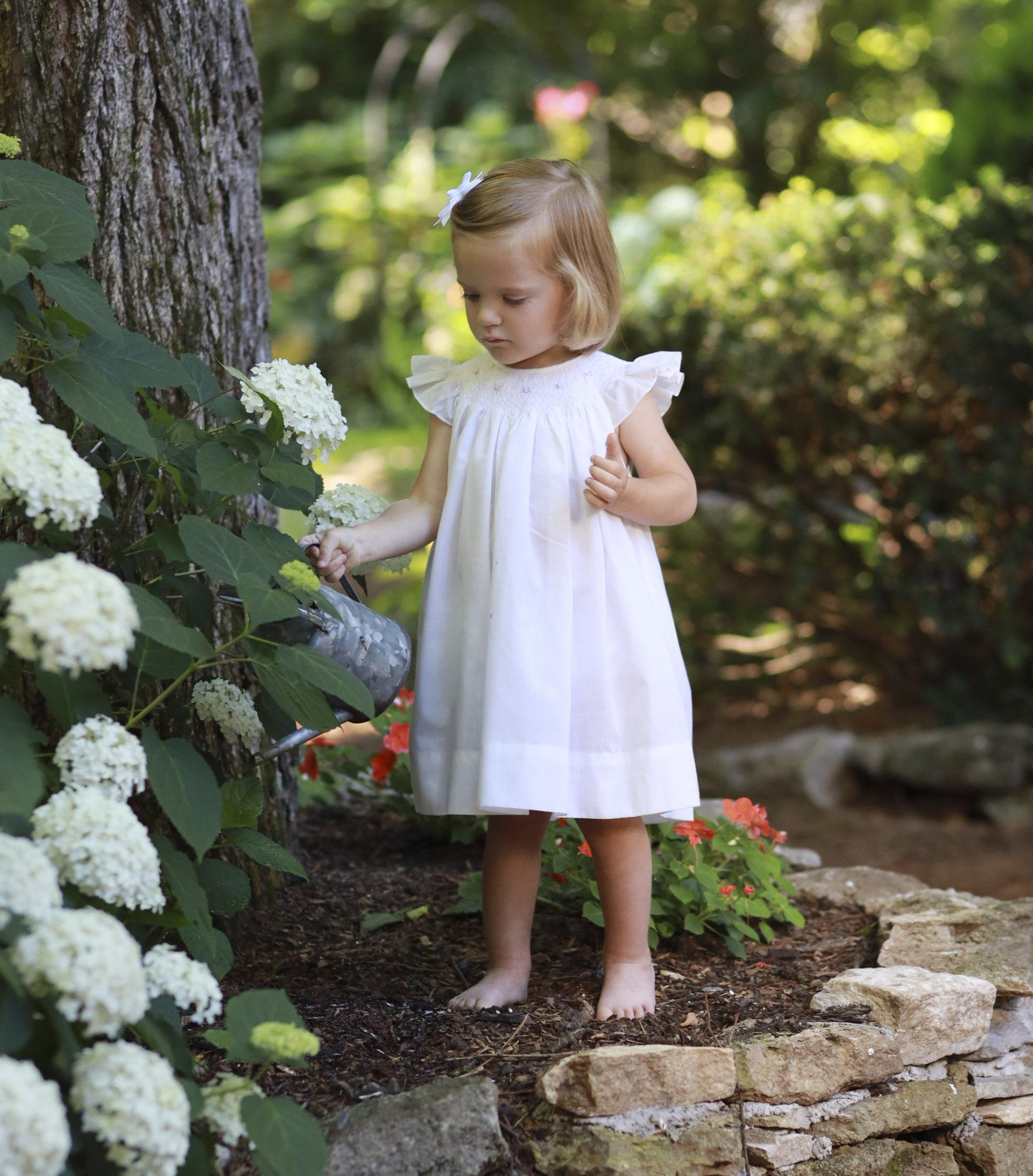 Portrait of child playing in the garden with flowers