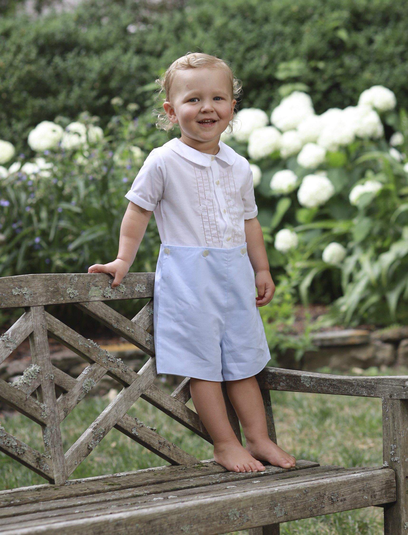 Outdoor picture of boy in garden with flowers