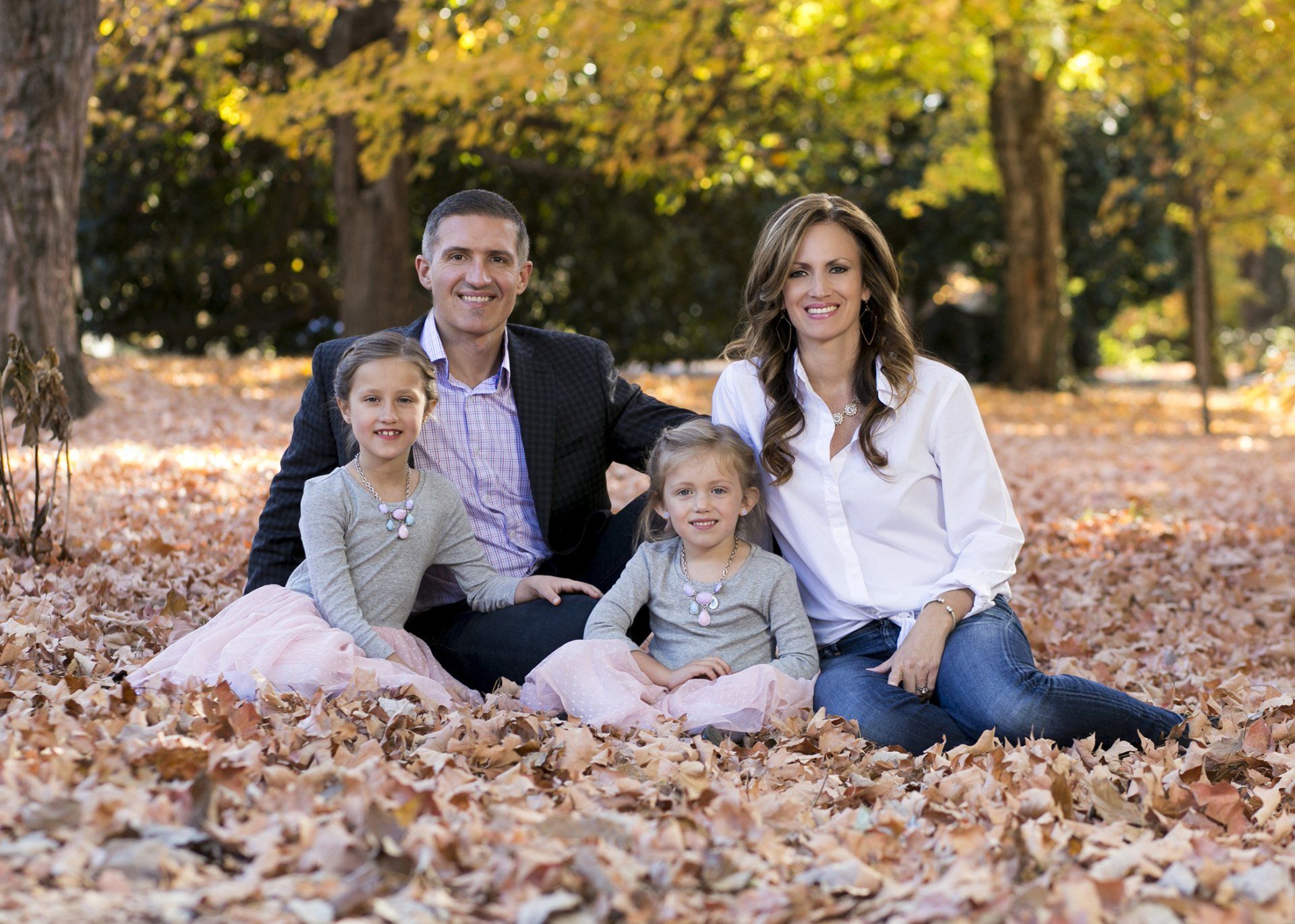 Outdoor portrait of family sitting in leaves
