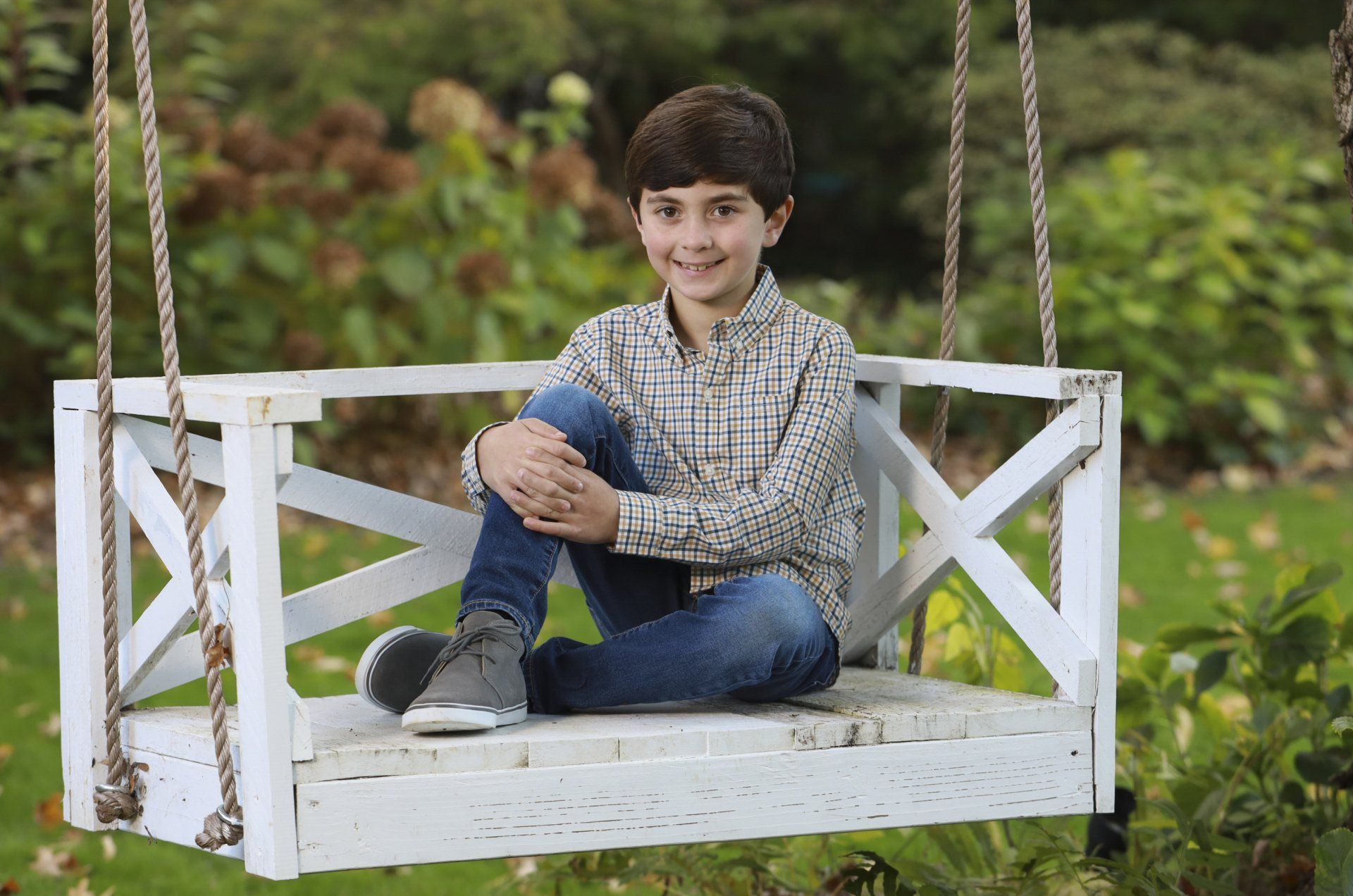 Photo of boy sitting on swing outdoors in Nashville