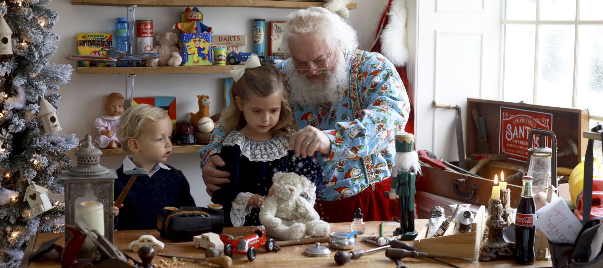 Boy and girl working with Santa in workshop