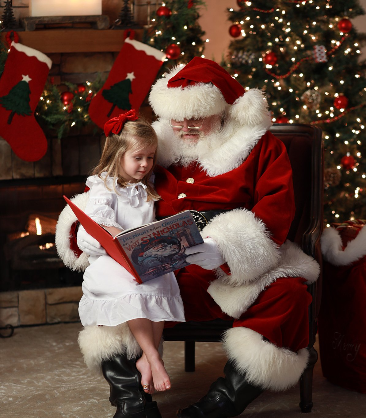 Child reading a book with Santa