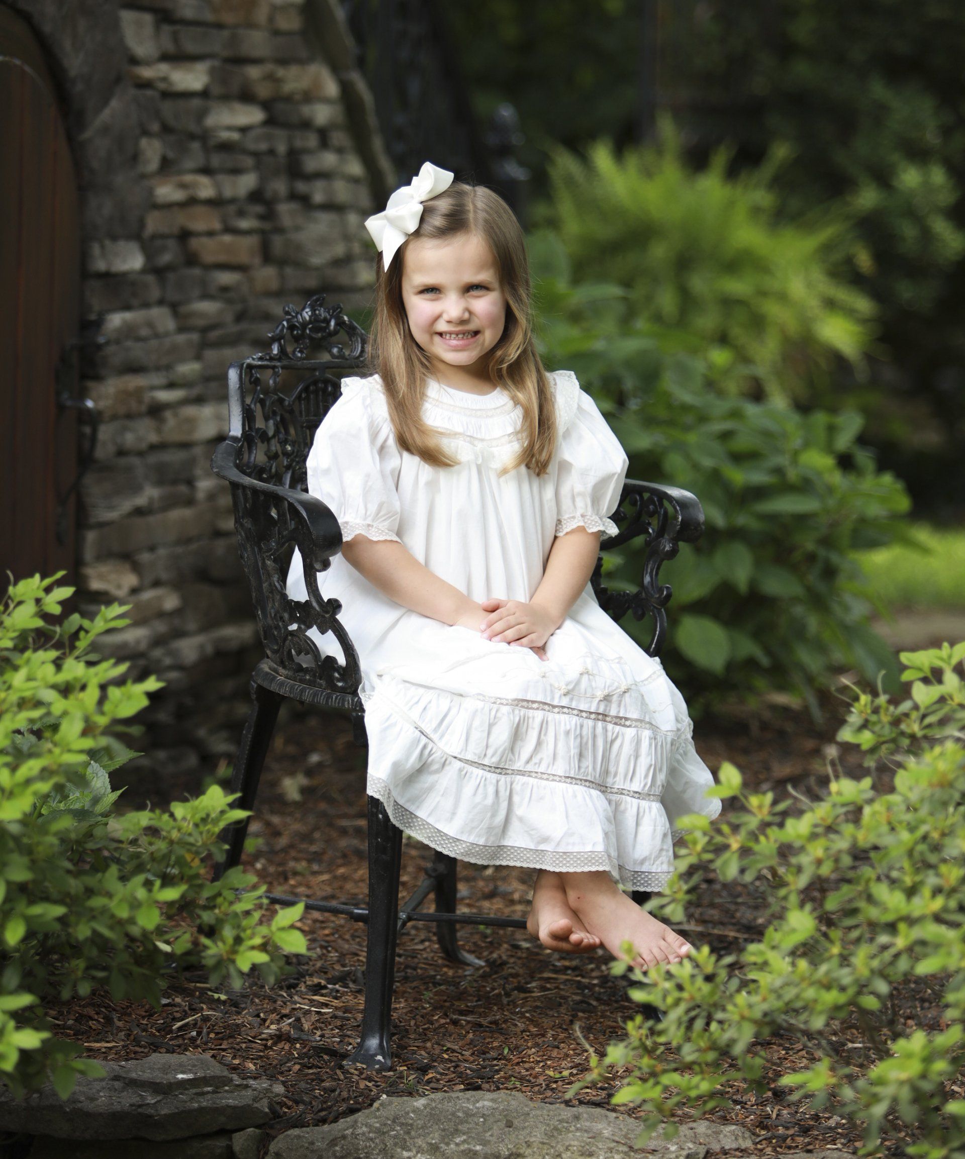 Outdoor portrait of girl on bench in garden