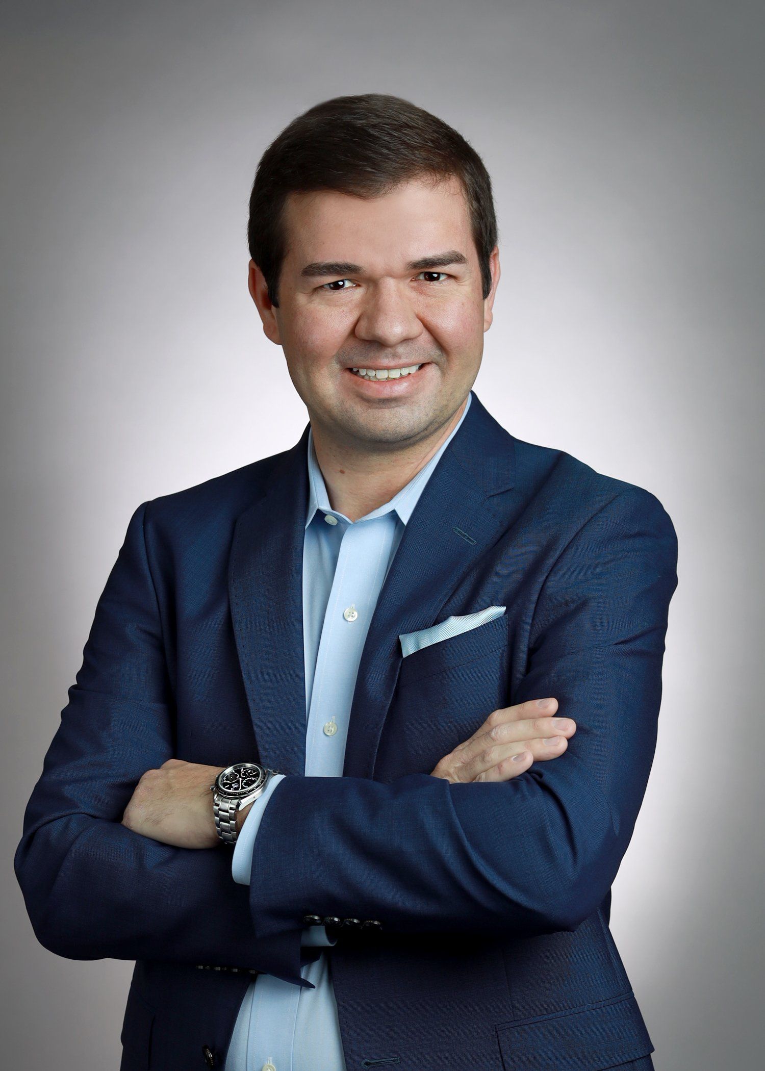 Business headshot of man with arms crossed