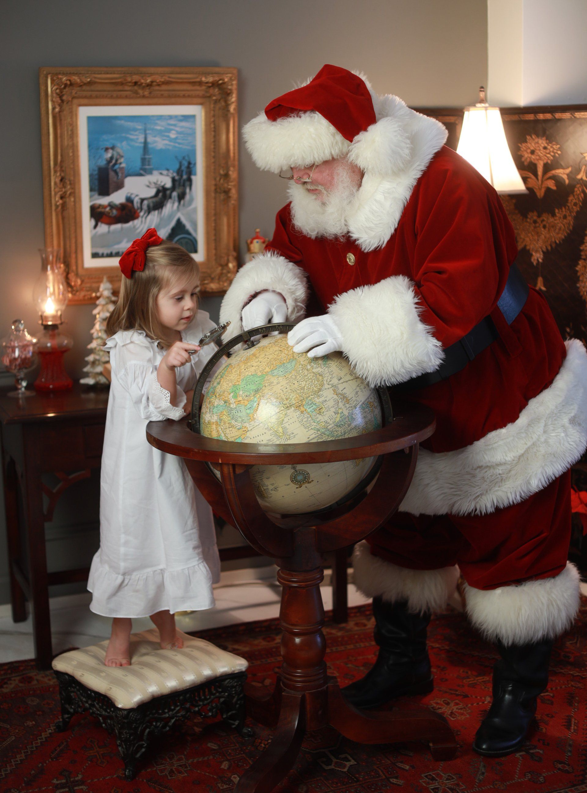 Santa and child exploring globe