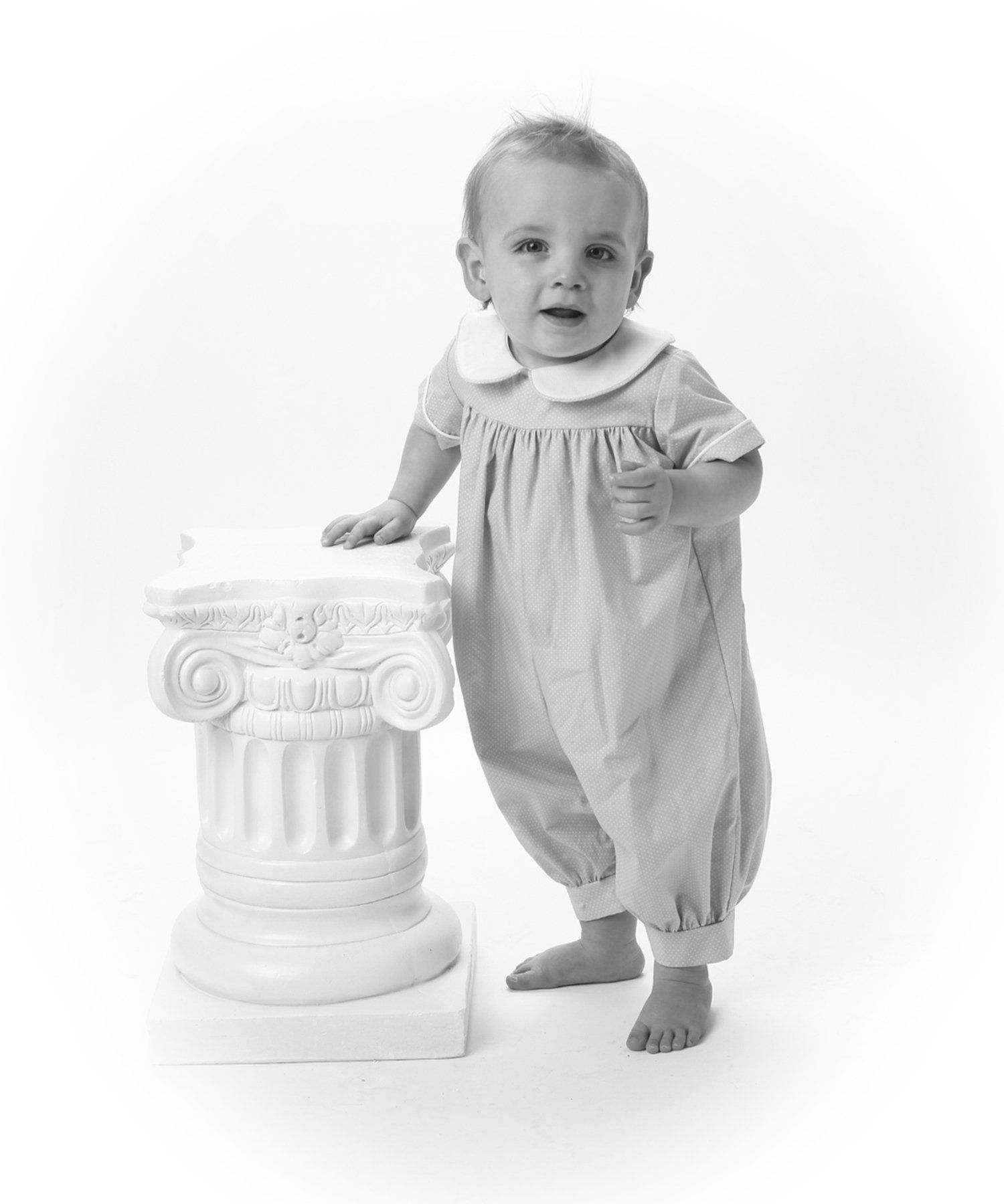 Vintage baby portrait standing by pillar