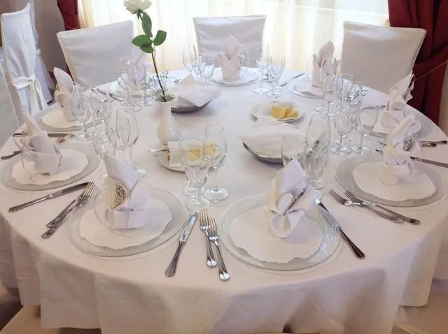 Un tavolo da pranzo rotondo apparecchiato per una cena formale