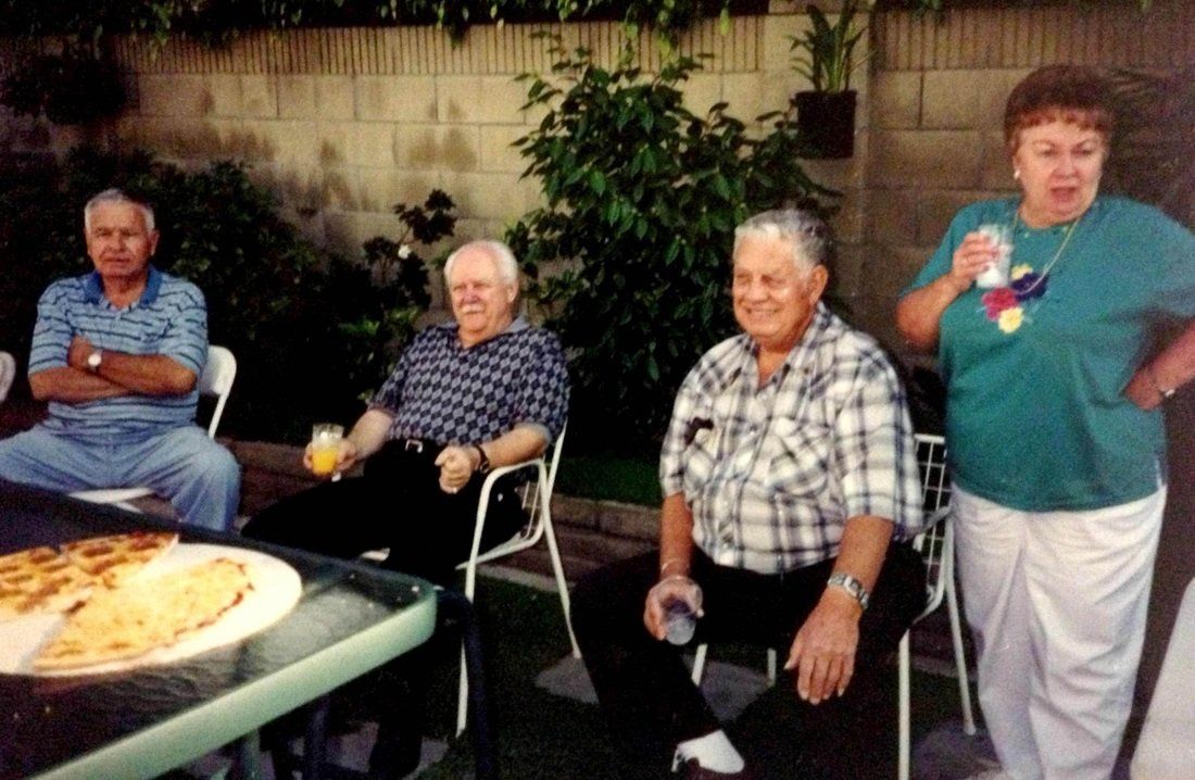 A group of people sitting around a table with a pizza on it