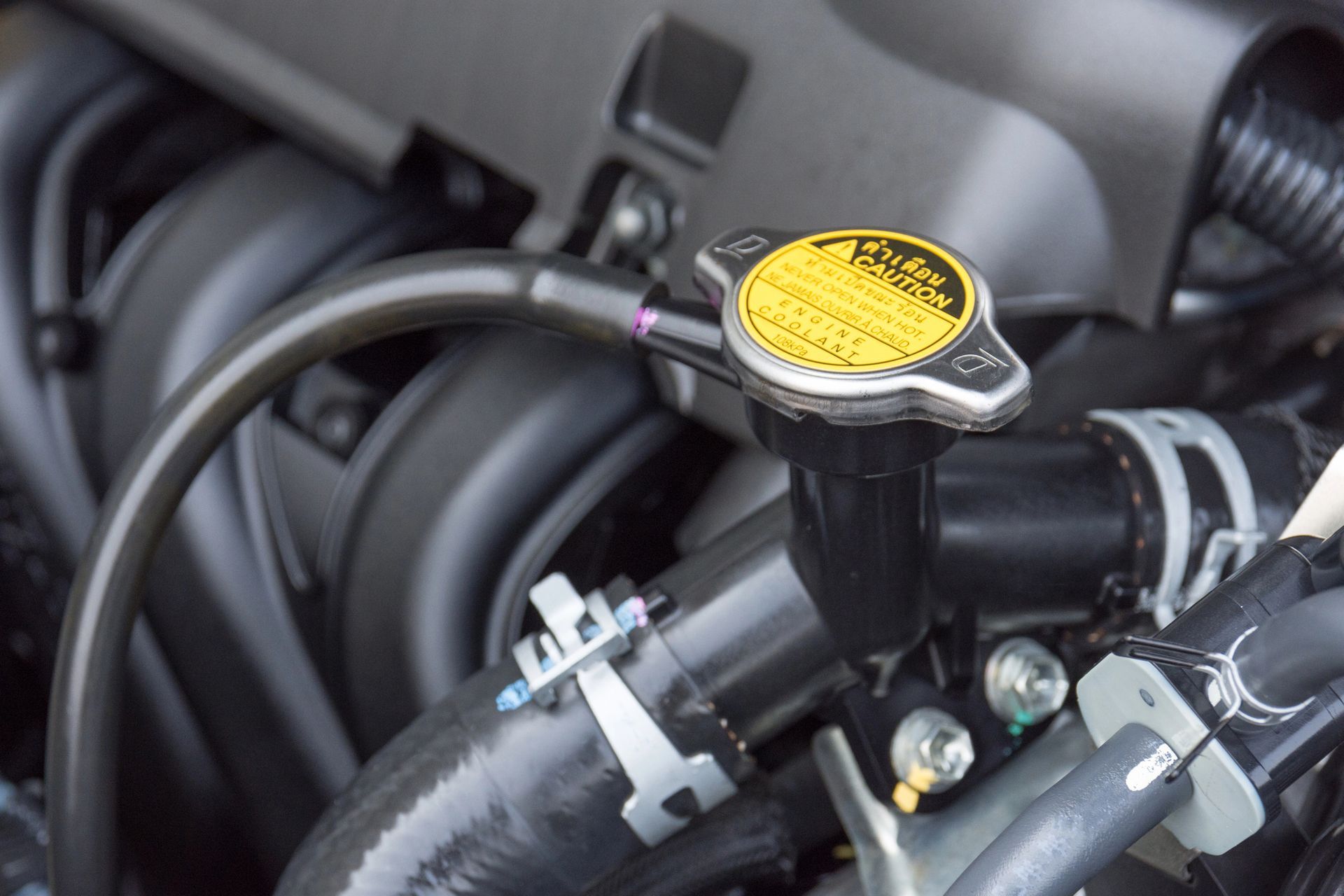 A close up of a radiator cap on an engine.