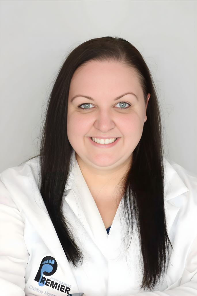 A smiling doctor in a lab coat with a stethoscope around his neck.