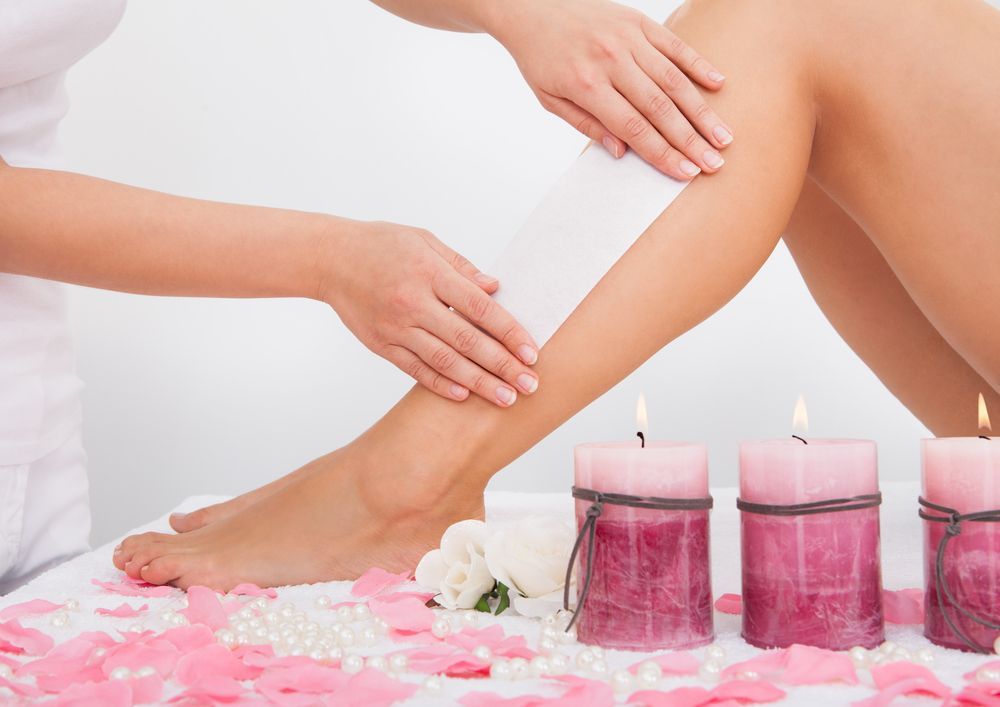 Leg Being Waxed With Candles, Petals, and Pearls in a Spa Setting — Aspire Beauty & Nails in Wagga Wagga, NSW