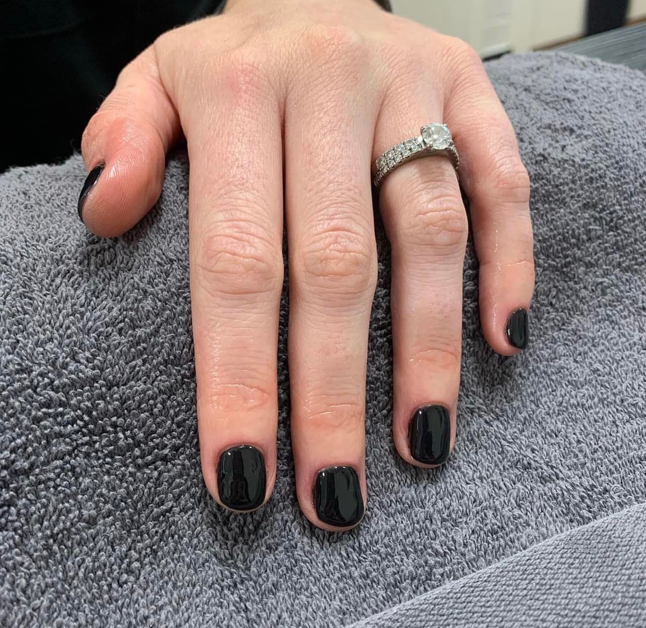 Hand with Short Black Nail Polish Wearing a Diamond Ring — Aspire Beauty & Nails in Wagga Wagga, NSW