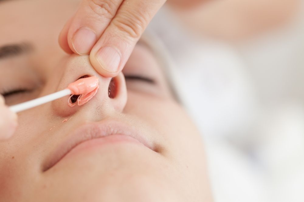 Person Having Nose Hair Removal With Wax Applied by a Stick — Aspire Beauty & Nails in Wagga Wagga, NSW