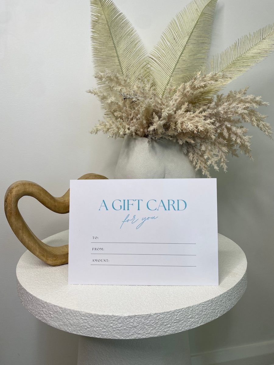 A Gift Card On A White Pedestal With Dried Beige Flowers — Aspire Beauty & Nails in Wagga Wagga, NSW