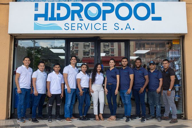 Un grupo de personas paradas frente a una tienda llamada hidropool service sa