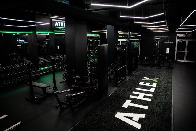 Une salle de sport avec un tapis sur lequel est écrit athlex.