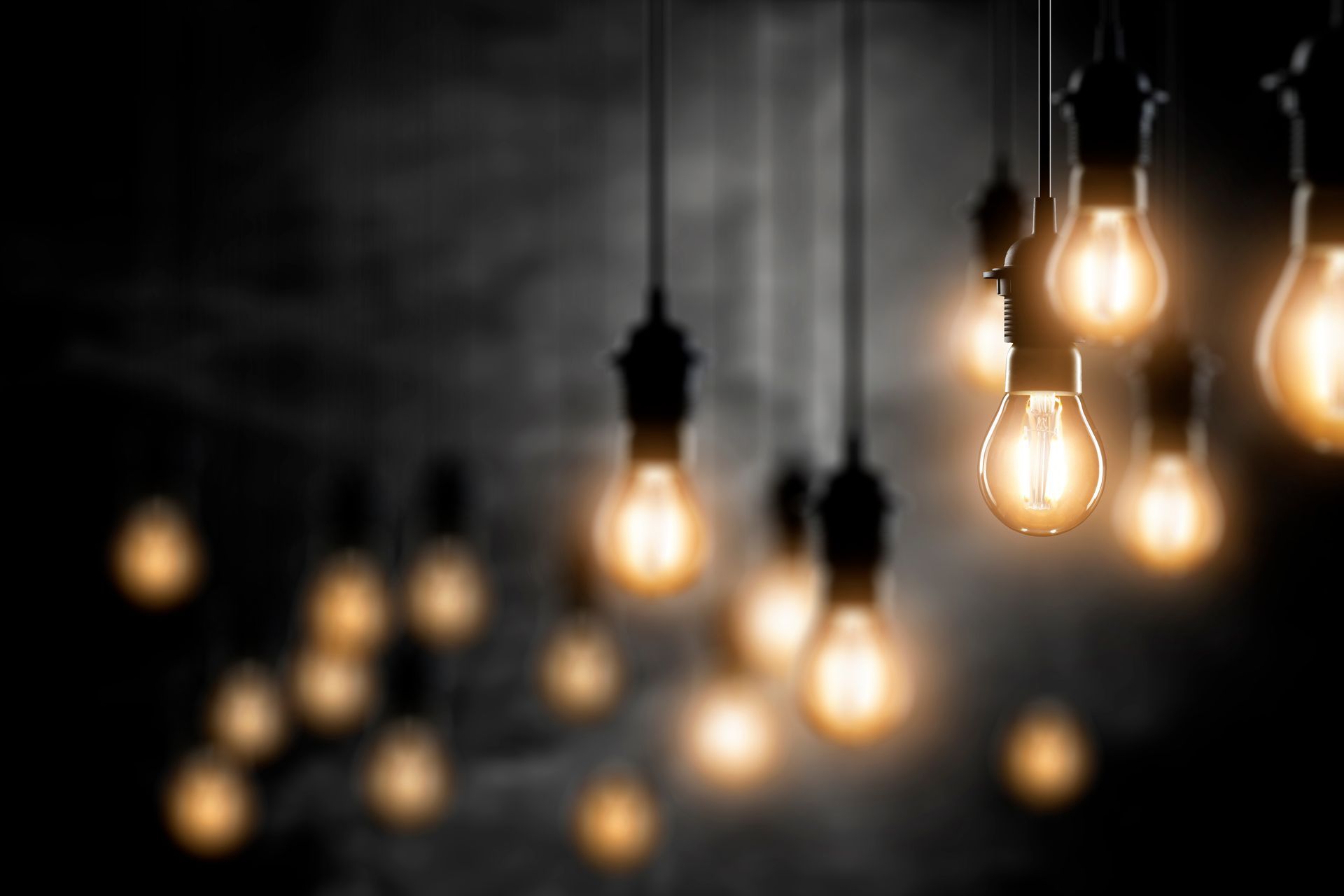 Un tas d'ampoules suspendues au plafond dans une pièce sombre.