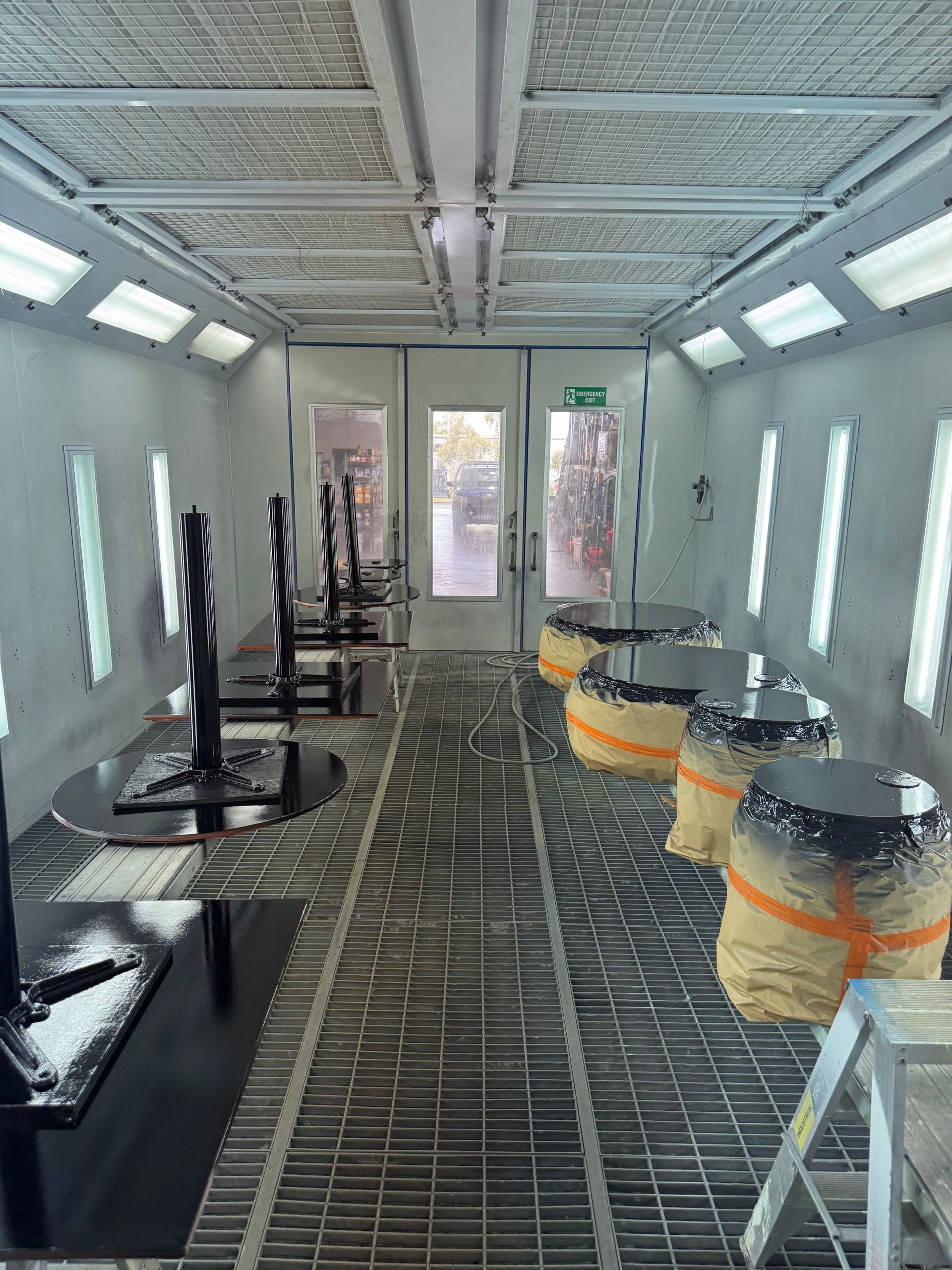Worker in hard hat using a laser level inside an unfinished room under construction