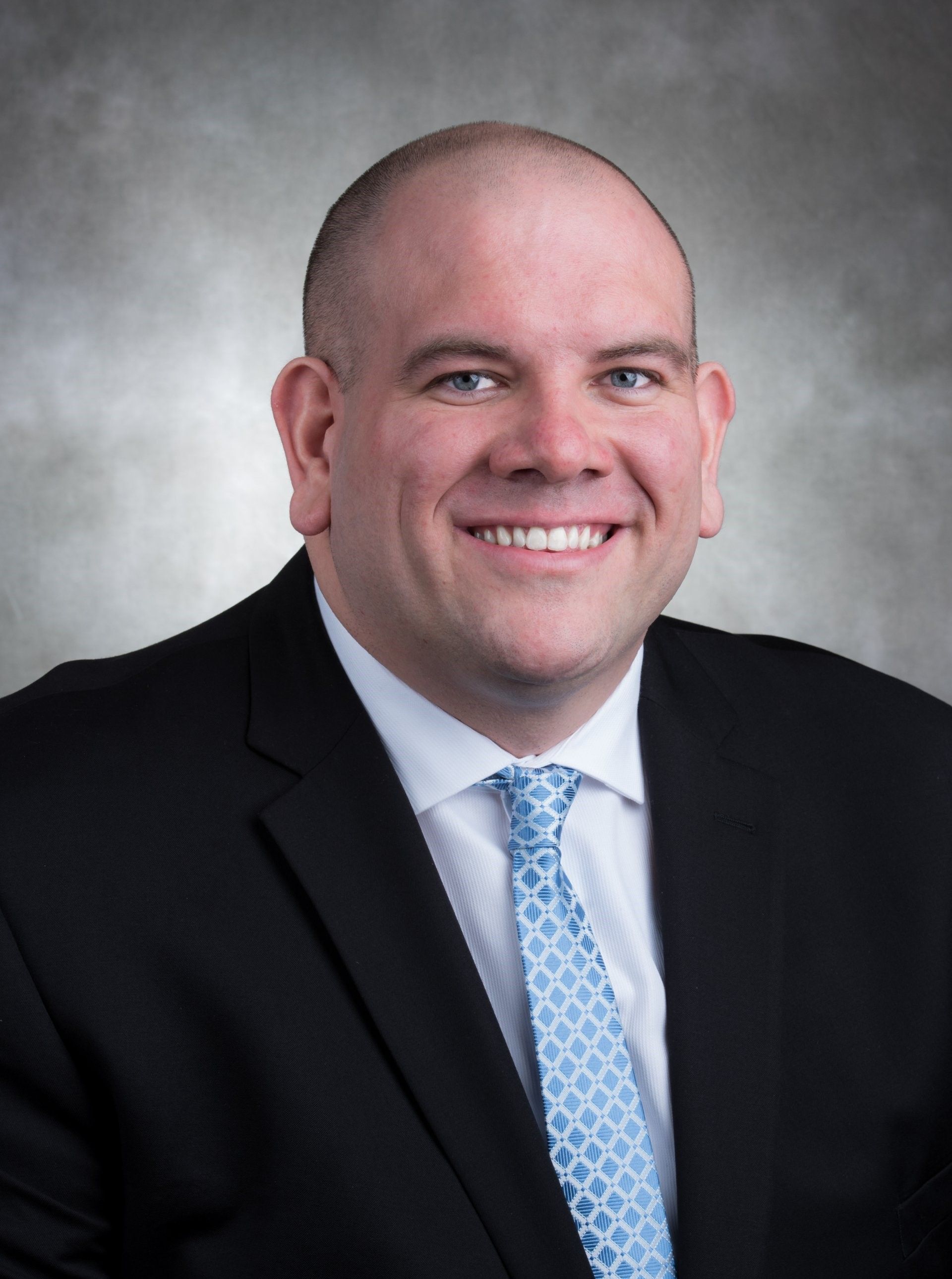 A man in a suit and tie is smiling for the camera.