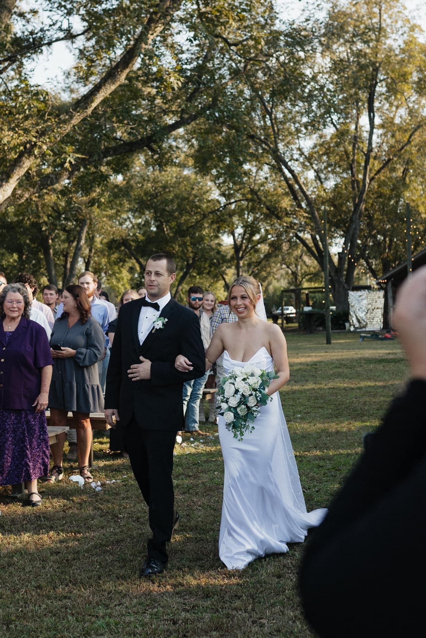 groom and bride holding white wooden bridal bouquet
