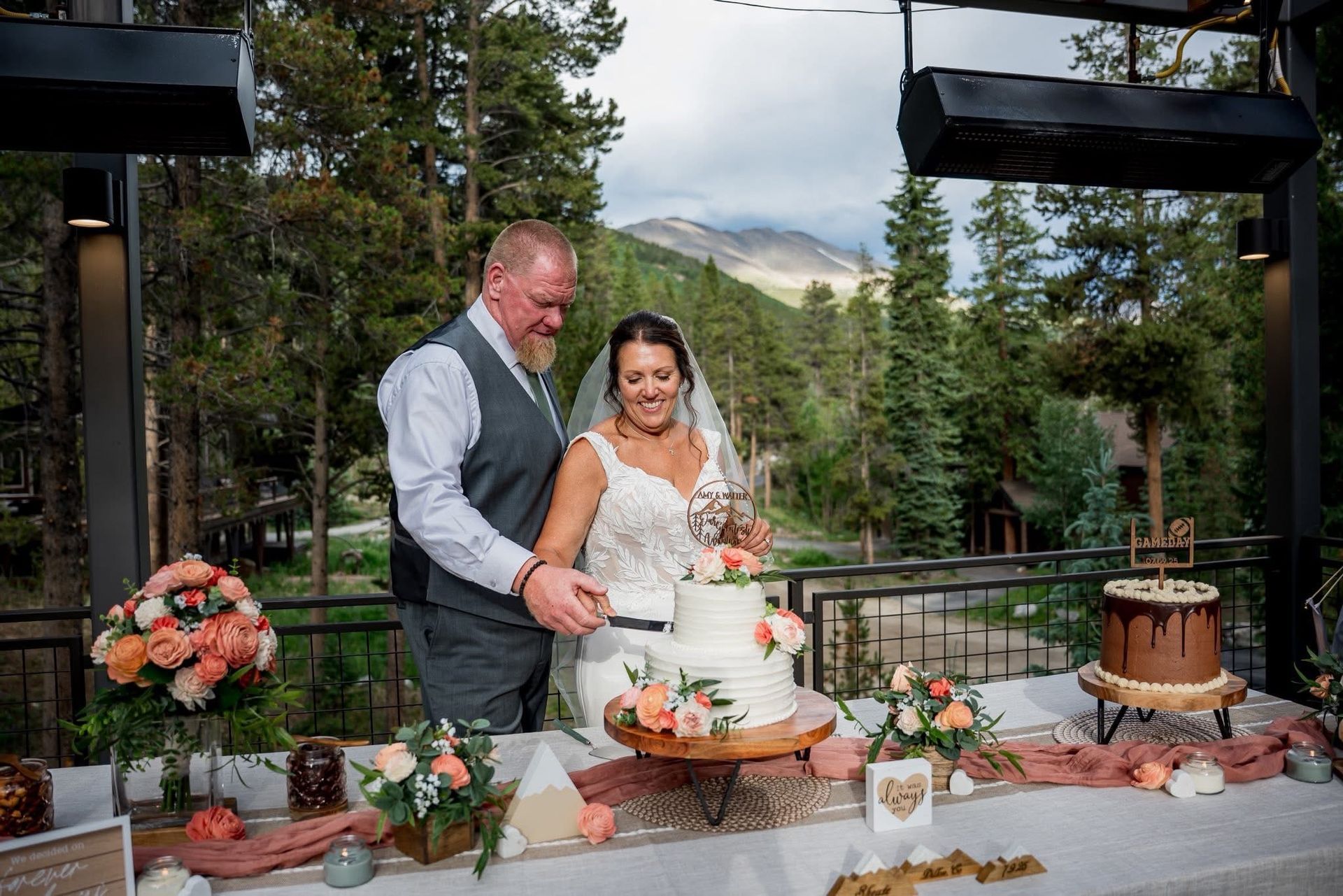 bride and groom cutting cake with wooden floral cake topper
