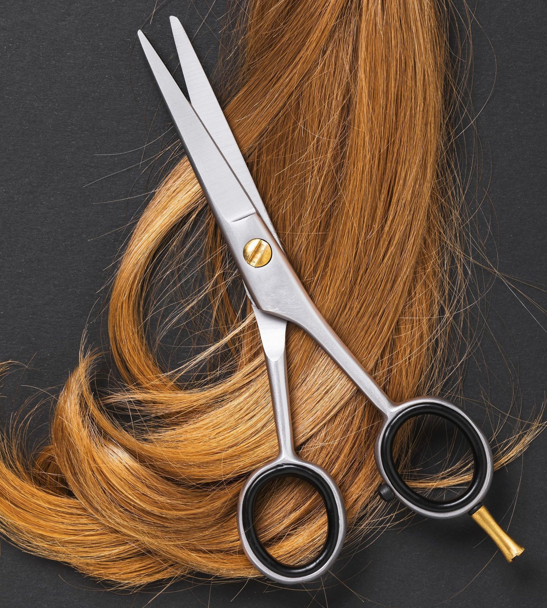 A pair of scissors sitting on top of a bunch of hair.